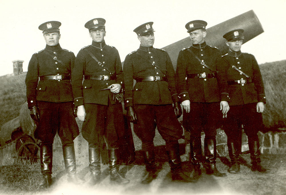 In 1935, the police uniform turned more military in style as a strap running from the belt over the shoulder was introduced. This strap for commanding officers was made of shiny leather, others wore one made of regular black leather. State Police School students on the walls of Suomenlinna Fortress in the late 1930s.