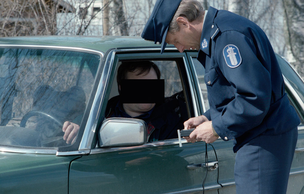 The bottom colour of the collar straps had been black on the uniform coat of 1951, but was changed to light blue in 1983. Light blue collar straps were also added to the field jacket of 1968. Constable of the Kuopio Police Department tests a driver for intoxication.