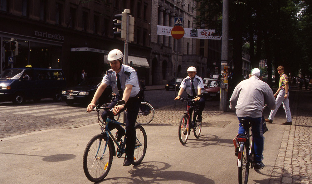 På 1990-talet blev det i de större städerna tillåtet att använda cyklar som patrullfordon. Cykelhjälmen infördes därför som ett uniformsplagg 1993. Tidiga cykelpoliser i Helsingfors 1995. Fotograf: Kim Stenvall.