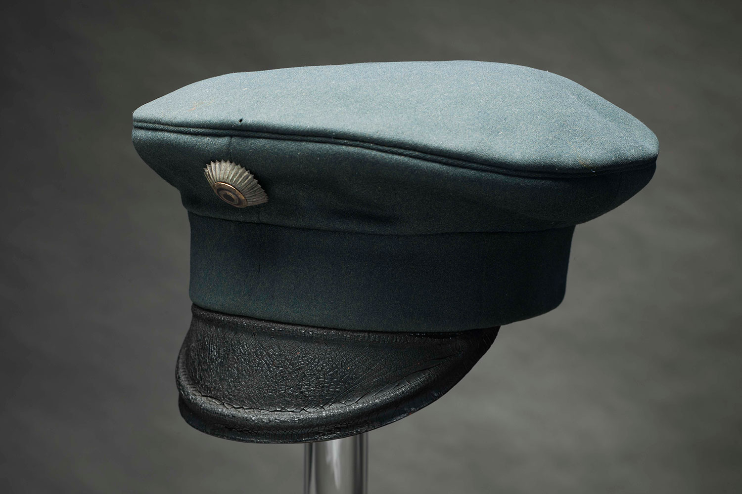 Nimismiehet käyttivät 1800-luvun lopussa maaseudulla lipallista vihreää virkalakkia, jonka etuosaan oli kiinnitetty virkakokardi. Venäläisperäinen tummanvihreä väri oli tyypillinen läänien virkamiesten puvuille. Kuvan lakki on kuulunut Oriveden nimismies Carl Danielsille. Kuva: Museokuva Matti Huuhka.