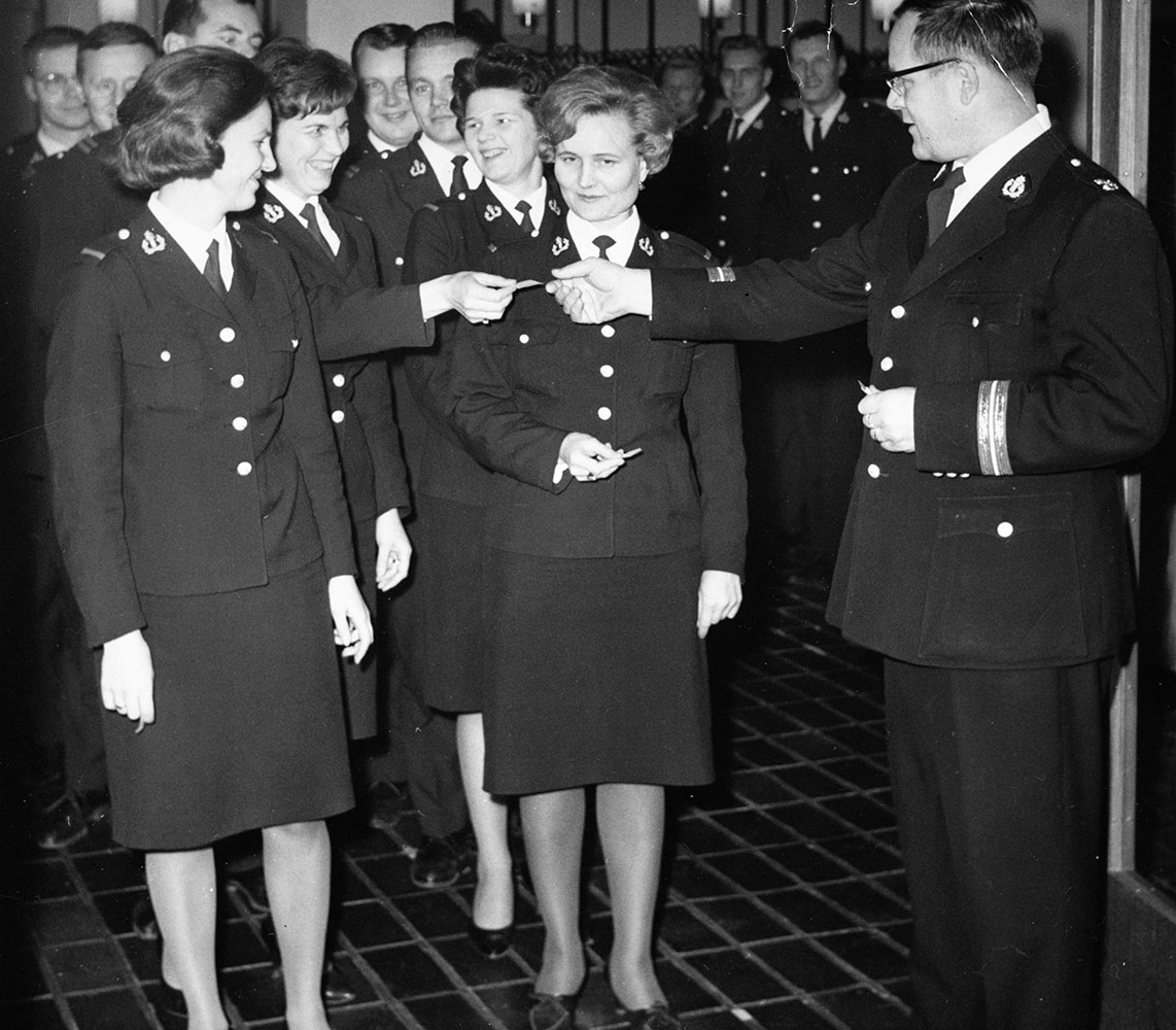 Kun naisia alkoi tulla järjestyspoliisin palvelukseen, heidän piti teettää virkapukunsa mittatilaustyönä, koska valmiita malleja naisille ei ollut. Virkapukupäätöksessä vuonna 1951 naiskonstaapelien puvuksi määriteltiin avokauluksinen virkatakki ja hame. Kurssilaisia Poliisiopistossa 1960-luvun alussa.