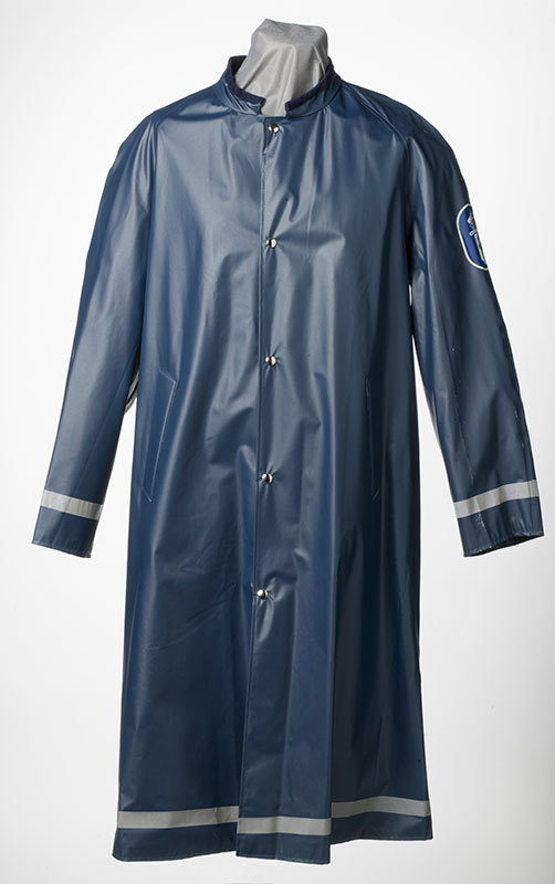 Vuonna 1971 poliisin sadetakki sai heijastinnauhat alahelmaan ja hihansuihin. Tummansininen sadetakki tuli takaisin käyttöön mustan rinnalle vuonna 1983 ja sai samalla miekkaleijonatunnuksen vasempaan hihaan. Kuva: Museokuva Matti Huuhka.